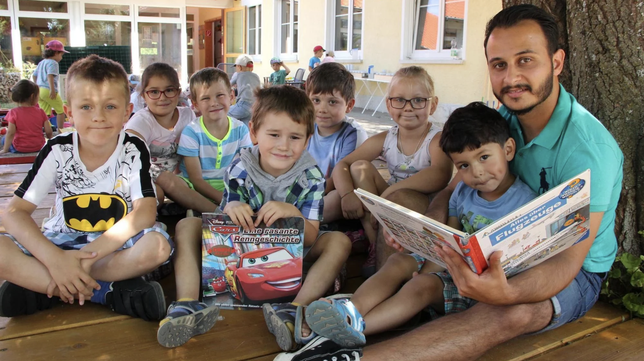 Arman Gül liest im Familienzentrum gemeinsam mit Kindern in einem Buch